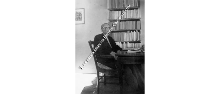 BLANCHOT : Photographie originale de Maurice Blanchot assis à sa table de travail devant la bibliothèque - Prima edizione - Edition-Originale.com